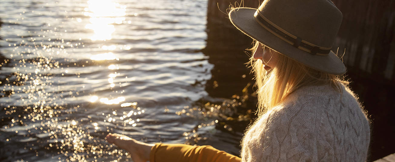 nainen rannalla hattu päässä